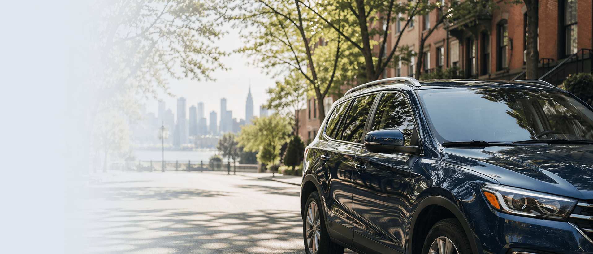 Black SUV on a New York City street with the Manhattan skyline in the distance